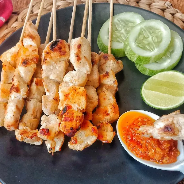 Sajikan sate taichan dengan sambal dan irisan timun.