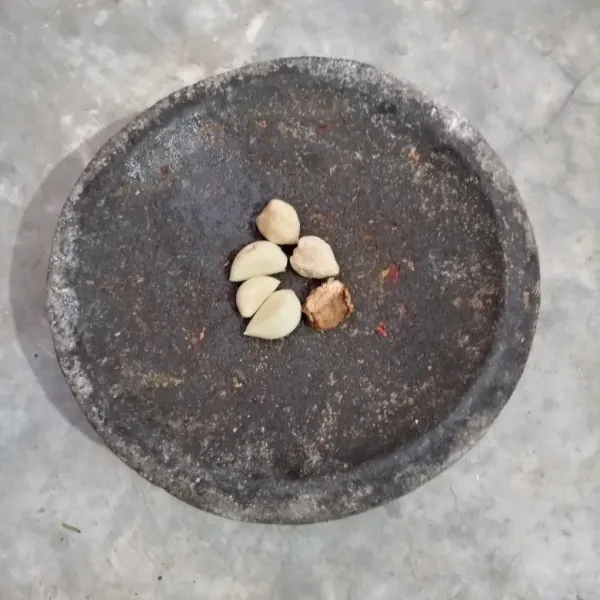 Haluskan bawang putih, kemiri, dan lengkuas.