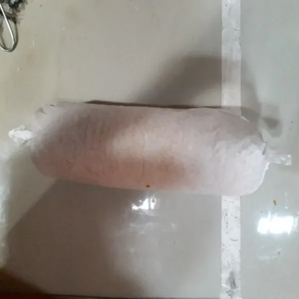 Gulung bolu dengan kertas roti lalu bungkus dengan kertas roti dan diamkan dalam kulkas selama 1 jam