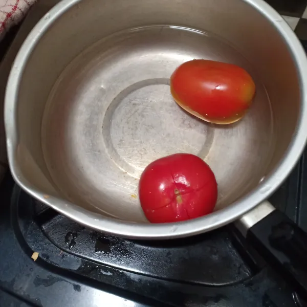 Buang ujung hitam pada tomat lalu kerat, rebus selama 2 menit