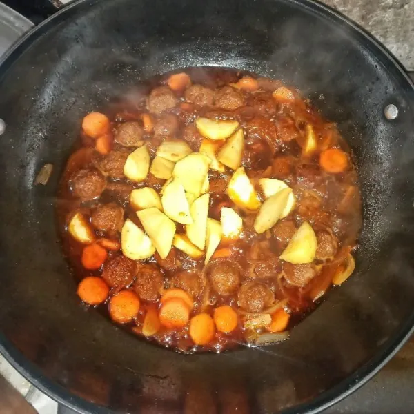 Masukkan campuran bahan saus, tunggu mendidih. Tambahkan wortel. tes rasa. Masak hingga air menyusut sedikit. Masukkan kentang yang telah digoreng, tes rasa. Masak sebentar hingga bumbu meresap