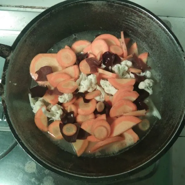 Masukkan wortel, brokoli dan jamur kuping. Aduk dan tambahkan air. Tumis hingga setenga matang.