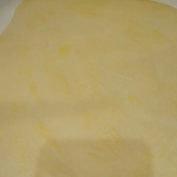 Gilas adonan hingga tipis kemudian oles dengan margarin cair