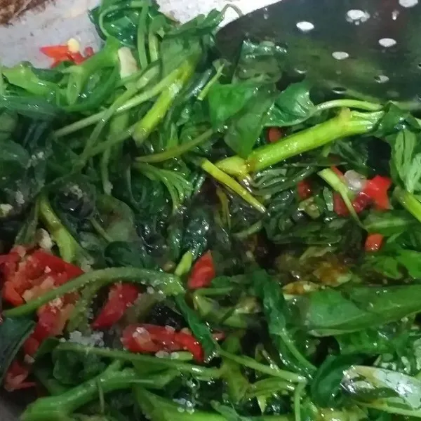 Masukkan kangkung, masak dengan api besar. Aduk rata lalu masukkan bumbu kaldu bubuk, garam, dan gula.