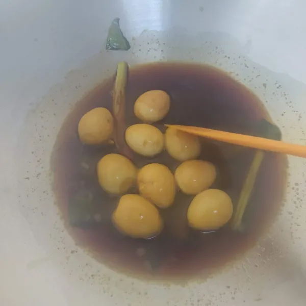 Aduk sesekali telur puyuh supaya warnanya merata. Beri garam dan koreksi rasa.