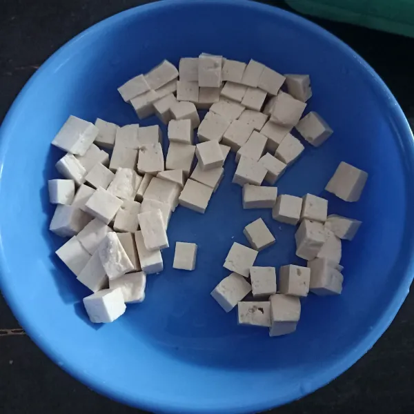 Potong tahu bentuk dadu, rendam selama 10 menit kemudian cuci bersih, tiriskan.