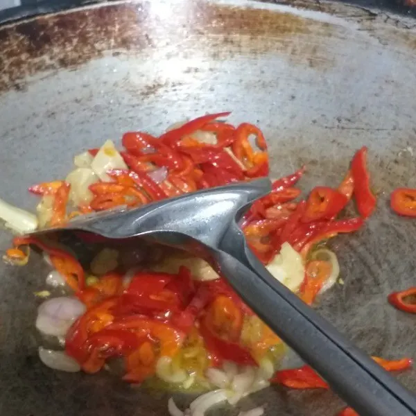 Panaskan minyak goreng lalu masukkan bawang merah, bawang putih, dan cabe merah besar. Tumis hingga harum.