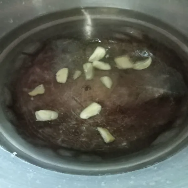 Didihkan air kemudian masukkan bawang putih dan jahe, biarkan mendidih.