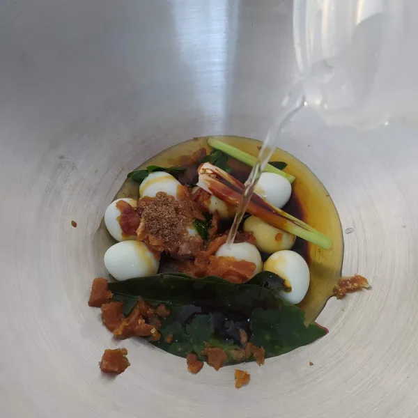 Masukkan telur puyuh kedalam wajan/ panci, tambahkan gula merah sisir, ketumbar bubuk, daun salam, daun jeruk purut, serai dan air. Nyalakan kompor, masak.