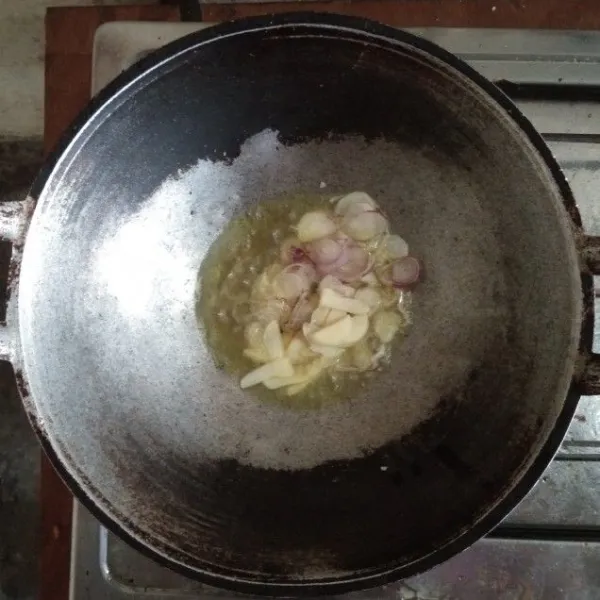 Tumis irisan bawang merah dan bawang putih dengan minyak goreng.