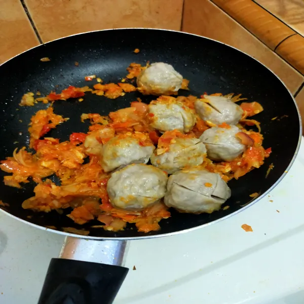 Masukkan bakso, masak hingga tekstur bakso sedikit kering.