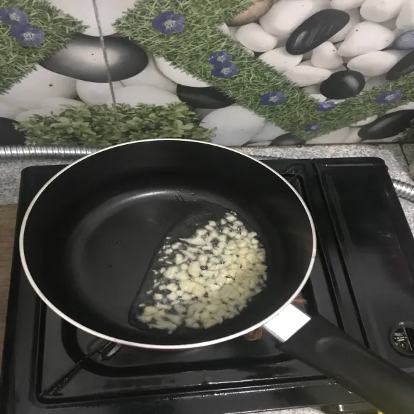 Masukkan minyak, tumis bawang putih hingga harum