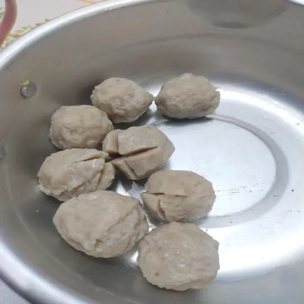 Rebus bakso dan potong seperti pada gambar agar saat dimasak bumbu bisa lebih menyerap.