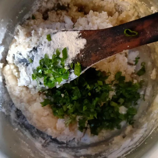 Masukkan bawang putih, garam kaldu bubuk. Tambahkan air lalu didihkan, masukkan tepung terigu, aduk-aduk lalu matikan api, masukkan daun bawang.