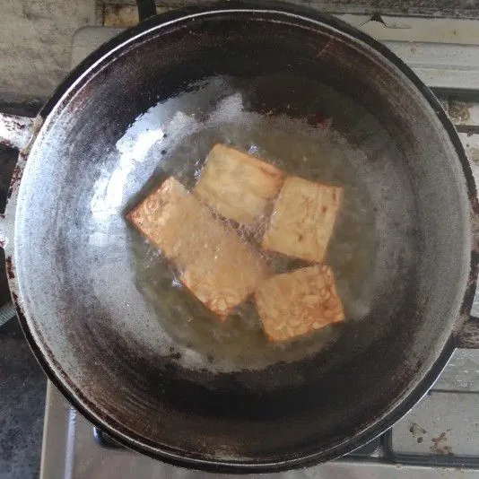 Goreng tempe dengan minyak goreng panas hingga matang.