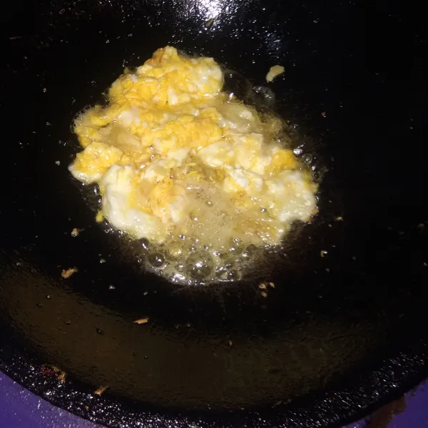 Buat telur orak arik, lalu tumis bawang putih sampai harum.