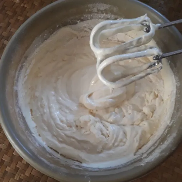Tambahkan tepung, dan susu bubuk sambil diayak, mixer sebentar hingga tecampur.