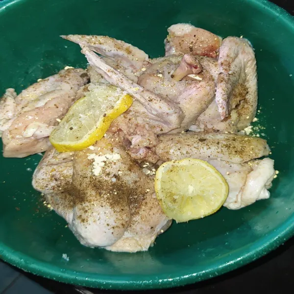 Cuci bersih sayap ayam, lalu bumbui dengan bawang putih bubuk, lada bubuk, garam dan juga perasan lemon. Simpan di kulkas selama 15 menit.