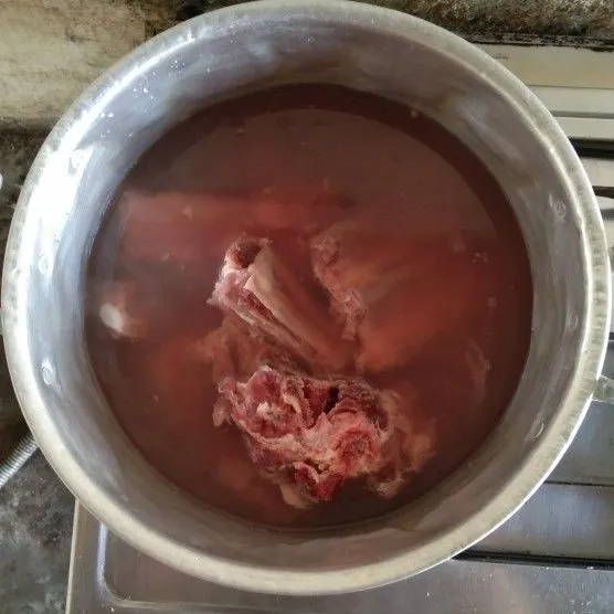 Rebus sebentar balungan untuk membuang sisa rebusan darah daging balungan yang nantinya bakal menggumpal. Ambili busa yang menggumpal dan buang.