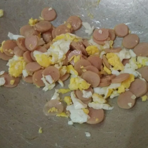 Buat telur orak arik, tambahkan potongan sosis tumis hingga matang, sisihkan.