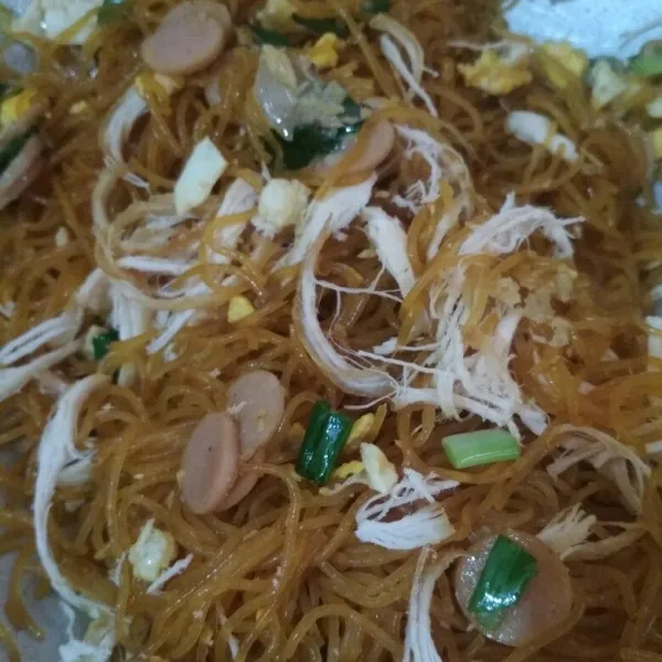 Masukkan bihun, orak arik telur, sosis, suwiran daging ayam, tambahkan kecap asin, saus tiram, kecap ikan, lada bubuk, dan kaldu bubuk aduk rata, koreksi rasa. Masak hingga bihun tercampur dengan bumbu, sajikan dengan taburan bawang merah goreng.