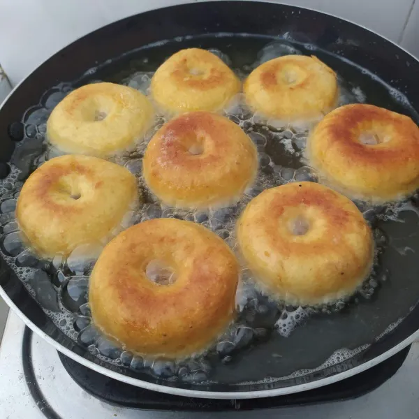 Setelah adonan mengembang, panaskan minyak. Kemudian lubangi bagian tengan adonan dengan jari, goreng hingga matang. Biarkan dingin, kemudian beri topping sesuai selera, sajikan.
