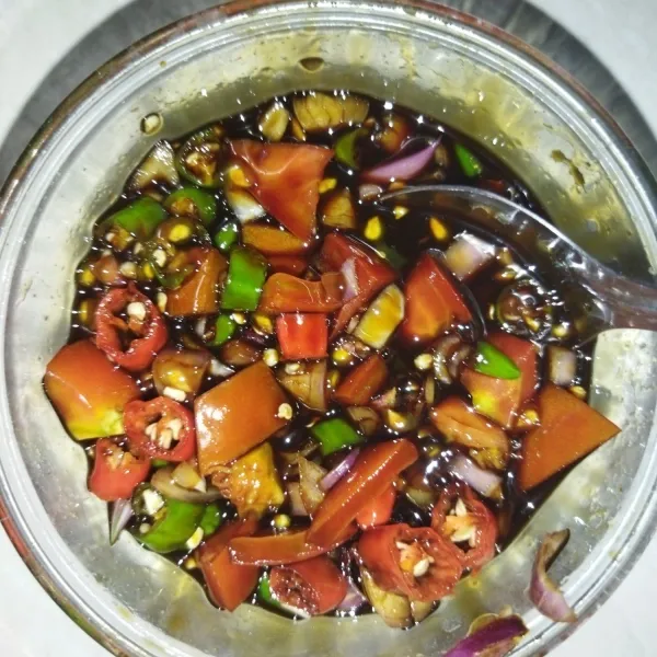 Sambal kecap: iris-iris cabe, tomat dan bawang merah, masukkan ke mangkuk, tuang kecap manis secukupnya, lalu beri air perasan jeruk limau, aduk rata.