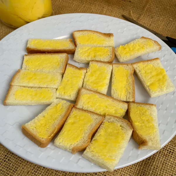 Potong roti tawar menjadi 8 bagian. Lalu olesi dengan margarin.