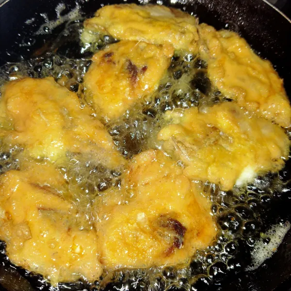 Panaskan minyak goreng hingga matang, bila masih ada sisa telur, ulangi balur ikan lalu goreng lagi.