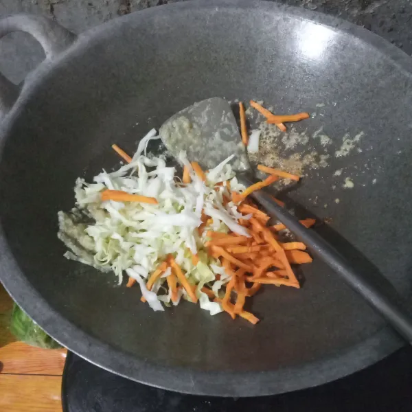 Masukkan wortel dan kol, aduk terus hingga wortel dan kol layu. Beri 3 sdm air agar wortel empuk.