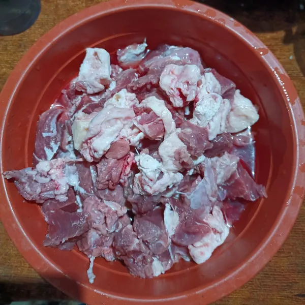 Bersihkan daging kambing dan potong sesuai selera.