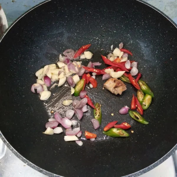 Tumis bawang merah, bawang putih, cabai merah, cabai hijau, cabai rawit dan lengkuas sampai harum dan layu.