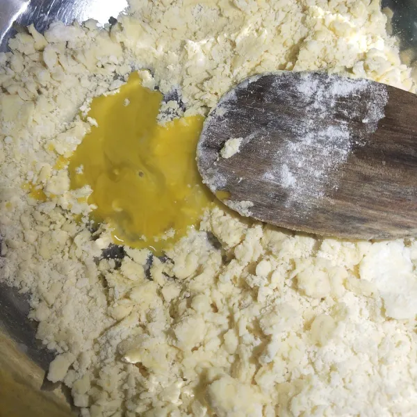 kemudian setelah adonan menjadi berbutir butir masukkan kuning telur dan 1 sendok makan air  kemudian uleni sampai kalis
