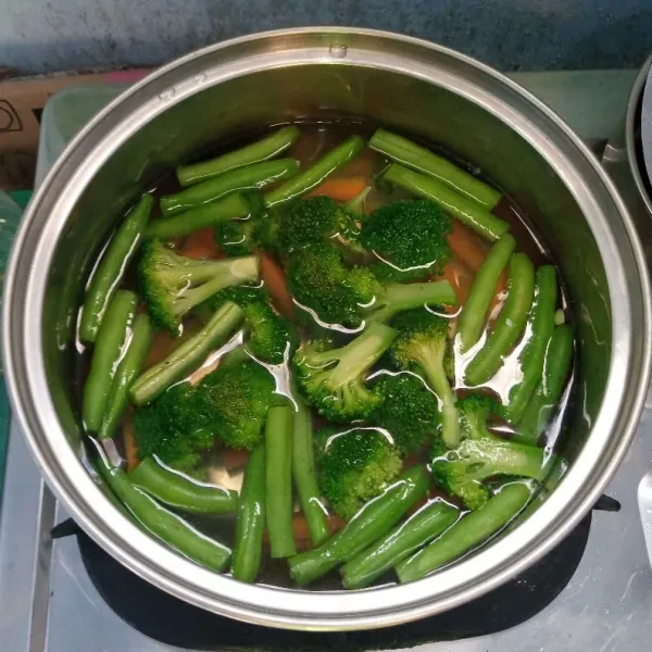 Rebus wortel dan buncis sampai setelah matang. Masukkan brokoli. Rebus sebentar. Angkat dan tiriskan.