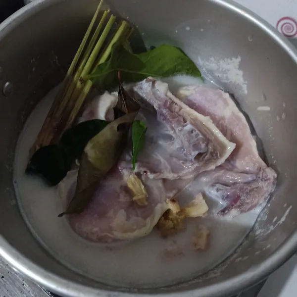 Rebus ayam yang sudah berbumbu, tambahkan rempah cemplung dan air kelapa (panci ditutup).