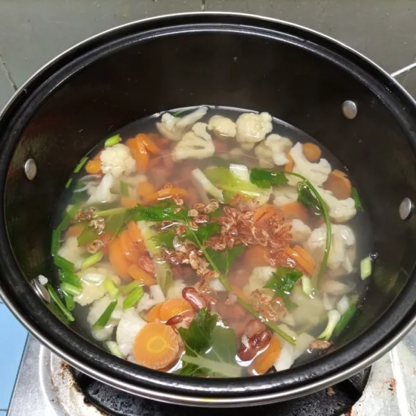 Masukkan daun prei dan seledri sembari tes rasa. Terakhir, masukkan bawang goreng. Sup matang, siap disajikan.