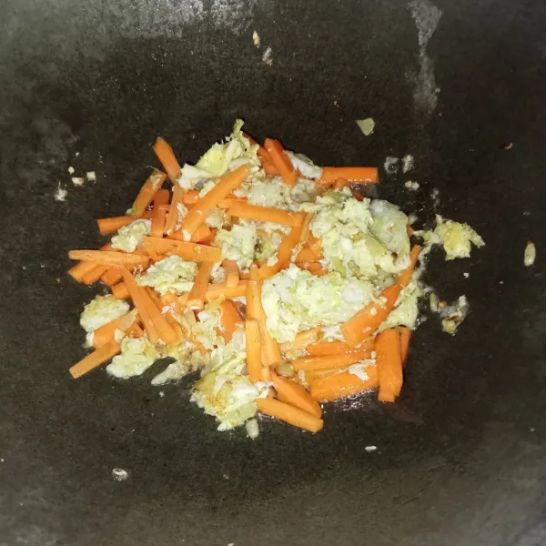 Masukkan wortel dan aduk rata, lalu tuang air dan masak hingga wortel setengah matang.