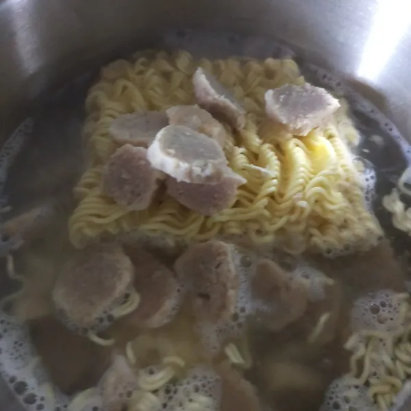 Rebus mie dan bakso di air mendidih.