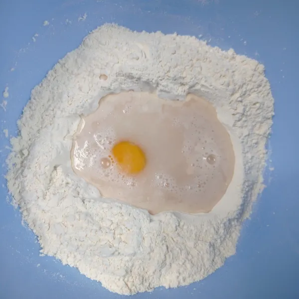 Tuang bahan biang ditengah, lalu tambahkan telur, kocok sebentar, lalu aduk rata dg tepung.