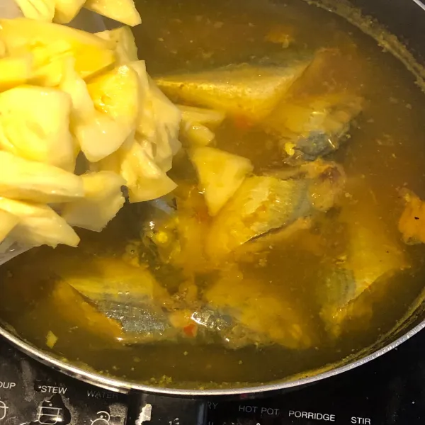 Masukkan air asam, gula, dan garam. Setelah ikan mendekati matang, masukkan nanas dan cabai rawit utuh.