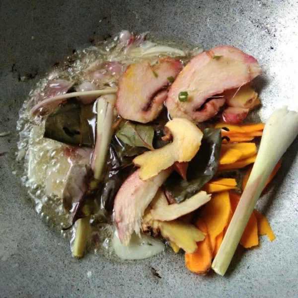 Tumis irisan bawang putih dan bawang merah hingga harum, masukkan daun salam, serai, kunyit, lengkuas dan jahe, aduk rata.