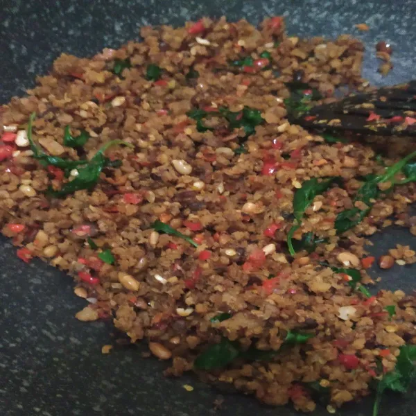 Masukkan kemangi lalu aduk hingga rata. Masak hingga kemangi layu.