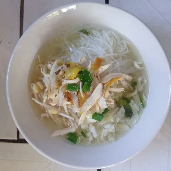 Sajikan soto dengan tata nasi, tauge, kubis, bihun, dan suwiran daging ayam di dalam mangkok. Tuang kuah soto.