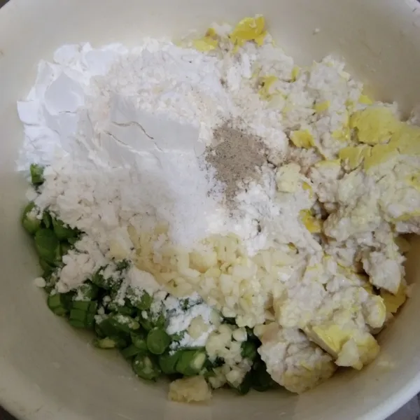 Dalam wadah campur tahu, buncis, tepung tapioka, tepung terigu, garam, kaldu jamur dan merica bubuk, aduk rata.