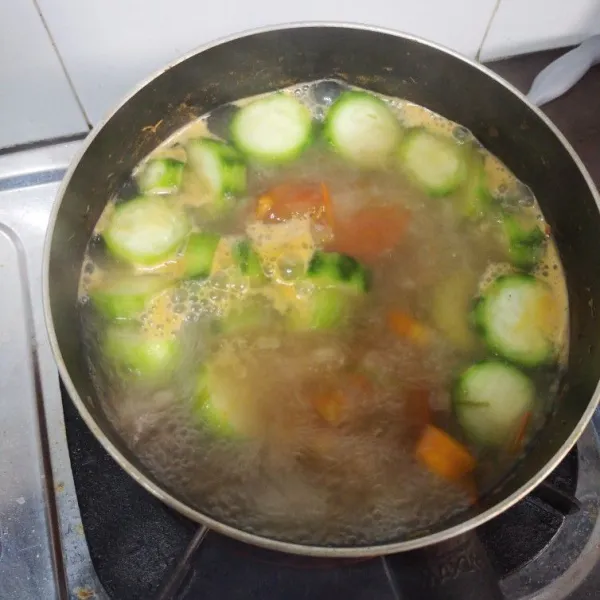 Tumis bawang putih, bawang bombay, dan bonggol daun bawang. Lalu haluskan. Masukkan dalam kuah kaldu, kemudian masukan wortel, tomat, dan oyong.