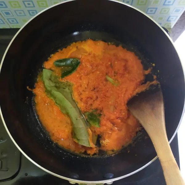 Tumis bumbu halus dengan sedikit minyak. Masukkan daun jeruk, daun salam, serai, lengkuas, dan daun kunyit. Masak hingga harum.