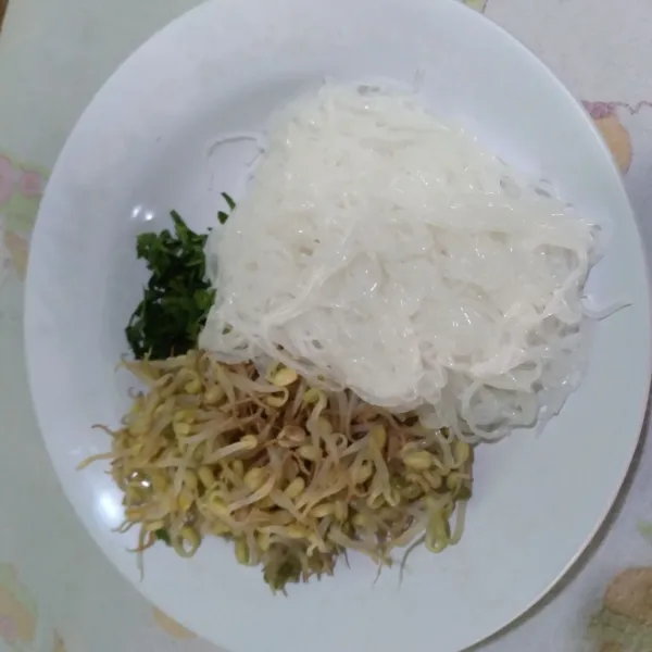 Rebus bihun dan tauge secara bergantian. Iris-iris seledri.