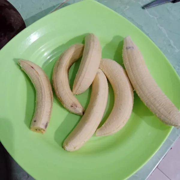Kupas pisang terlebih dulu.
