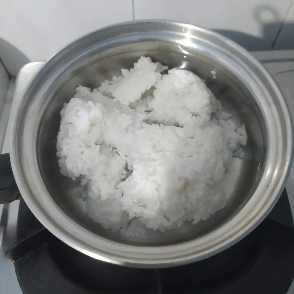 Masukkan nasi dan air, masak sampai mendidih.