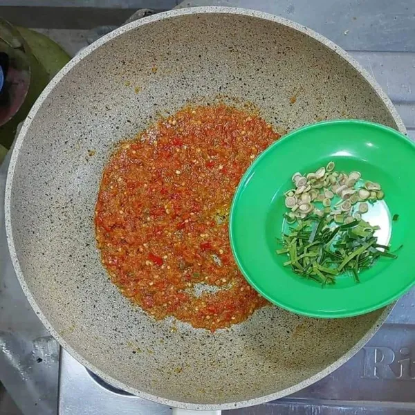 Masukkan irisan serai dan daun jeruk.